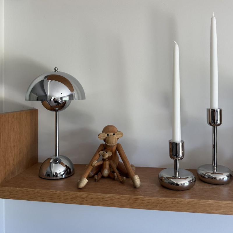 Kromad designlampa på ett stilrent sidobord i metall, en modern inredningsdetalj